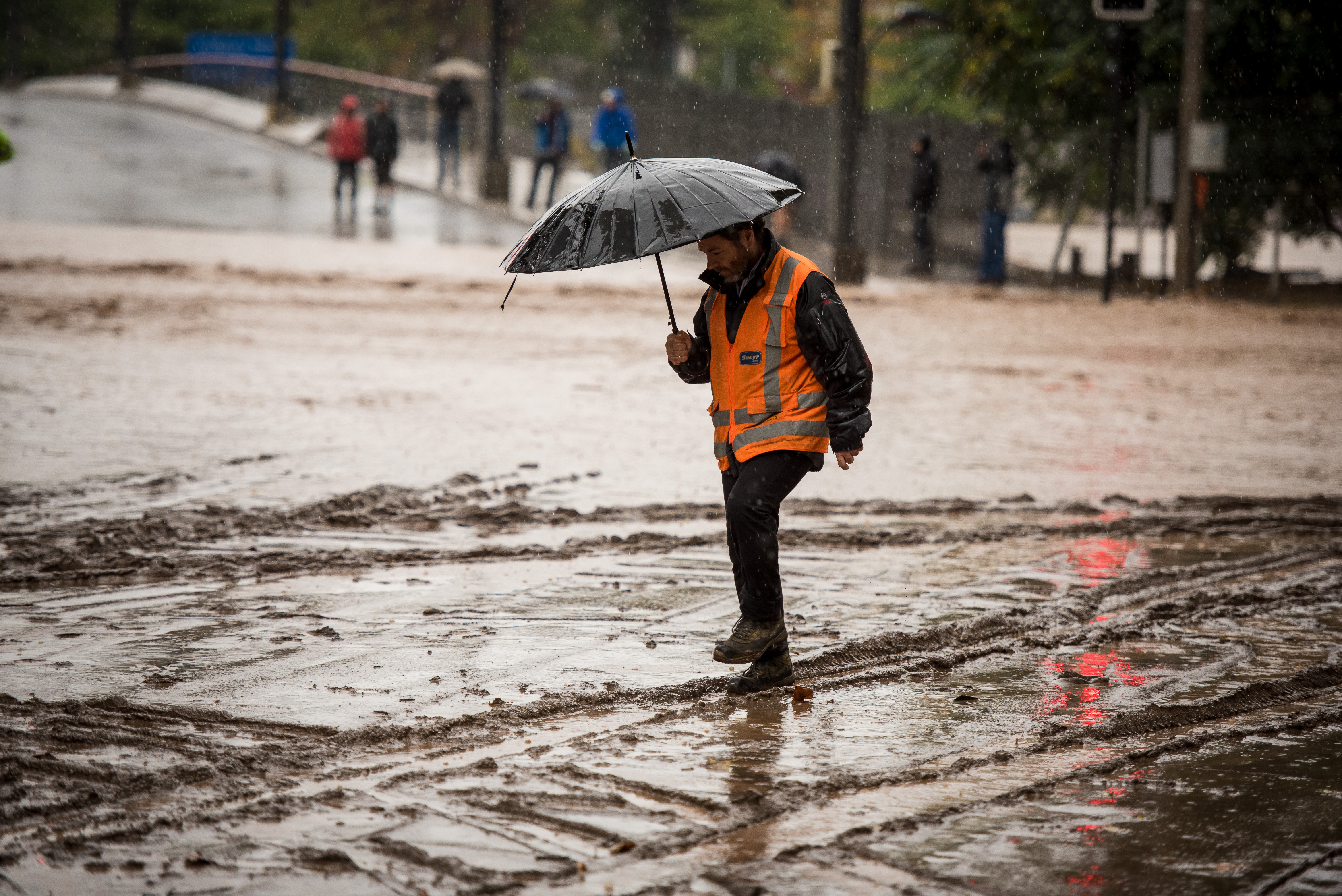 Hombre caminando por una calle inundada